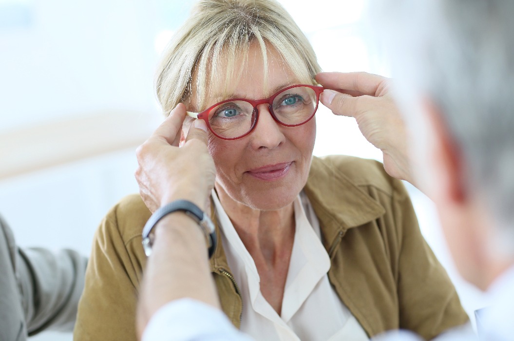 Ältere Frau probiert neue Brille an, Optikgeschäft
